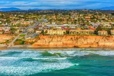a city on top of a cliff next to the ocean at Sand Pebbles Resort - Amazing 2 Bedroom Condo Right by the Beaches & Attractions in Solana Beach