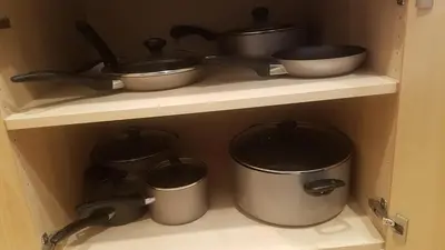 a shelf with pots and pans in a kitchen at Sand Pebbles Resort - Amazing 2 Bedroom Condo Right by the Beaches & Attractions in Solana Beach