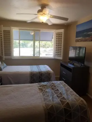 a bedroom with two beds and a flat screen tv at Sand Pebbles Resort - Amazing 2 Bedroom Condo Right by the Beaches & Attractions in Solana Beach