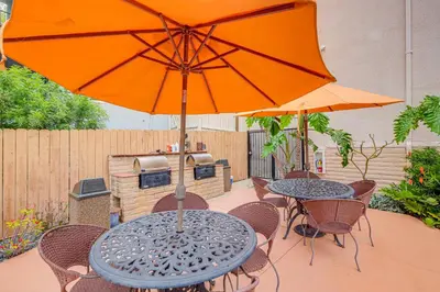 a table and chairs with an umbrella and a grill at Condo Near Hospitals and half Mi to Mission Bay! in San Diego