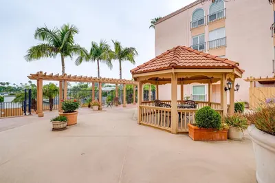 a gazebo on a patio with palm trees at Condo Near Hospitals and half Mi to Mission Bay! in San Diego