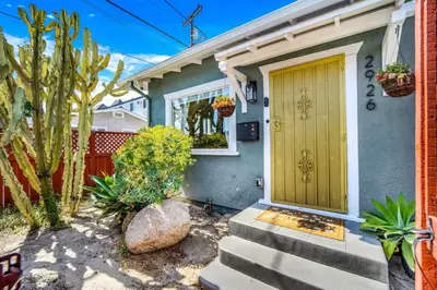 a house with a yellow door and some plants at North Park Boho Bungalow by Rather Be Properties in San Diego