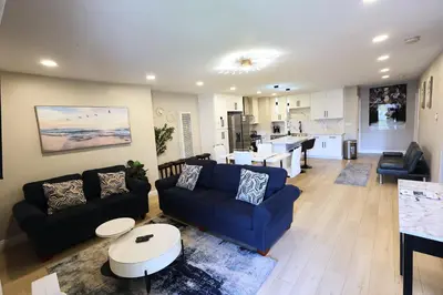 a living room with a blue couch and a kitchen at Exotic Homes Gillespie Dr by SD stay in Spring Valley