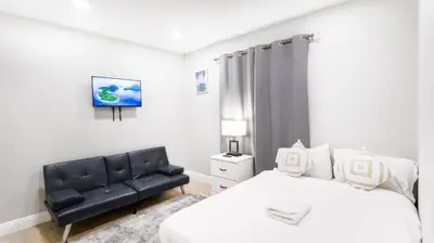a bedroom with a bed and a black leather couch at Exotic Homes Gillespie Dr by SD stay in Spring Valley