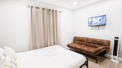 a bedroom with a bed and a leather chair at Exotic Homes Gillespie Dr by SD stay in Spring Valley