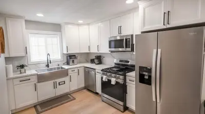 a kitchen with white cabinets and a stainless steel refrigerator at 8356 Adam back unit 2bed 2bath by sdstay in Lemon Grove