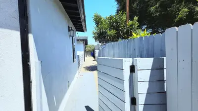 a white fence next to a white wall at 8356 Adam back unit 2bed 2bath by sdstay in Lemon Grove