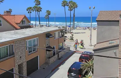 a view of a beach with cars parked on a street at Lower West Newport in Newport Beach