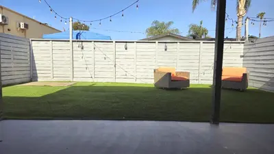 two chairs sitting on a lawn next to a fence at Gillespie 2bed 1 bath 1063 by SD Stay in Spring Valley