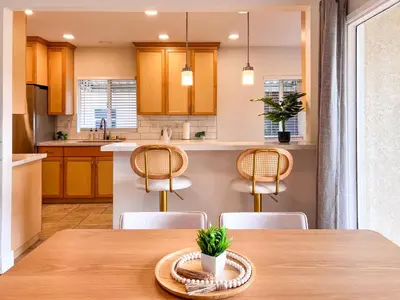 a kitchen with a wooden table and chairs at Modern Boho Oasis - Fast Wifi & Shuffleboard! in San Diego