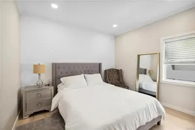a white bedroom with a bed and a mirror at 1628 West Oceanfront Oasis - 5,8,9 in Newport Beach
