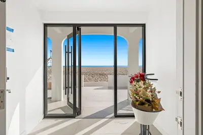 a room with a view of the beach through a glass door at 1628 West Oceanfront Oasis - 5,8,9 in Newport Beach
