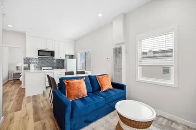 a living room with a blue couch and a kitchen at 1628 West Oceanfront Oasis - 5,8,9 in Newport Beach