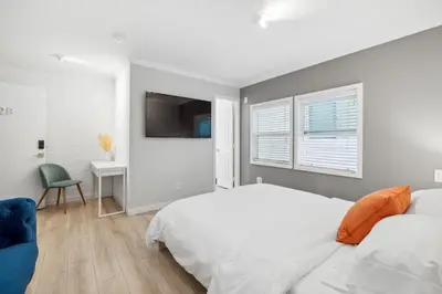 a white bedroom with a bed and a desk at 1628 West Oceanfront Oasis 1,2,3 in Newport Beach