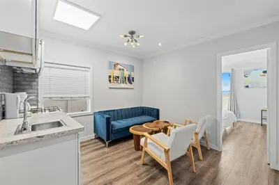 a kitchen and dining room with a table and a blue couch at 1628 West Oceanfront Oasis - 4,6,7 in Newport Beach