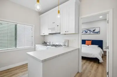 a kitchen with white cabinets and a bed in a room at 1628 West Oceanfront Oasis 4,5,6,7,8,9 in Newport Beach