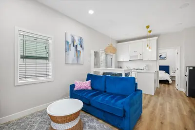 a living room with a blue couch and a kitchen at West Oceanfront Oasis 4 in Newport Beach