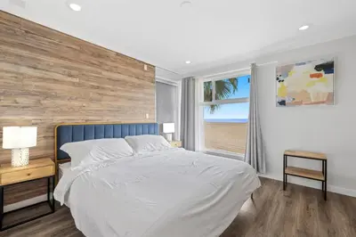 a bedroom with a large bed with a wooden wall at 1628 West Oceanfront Oasis 7 in Newport Beach