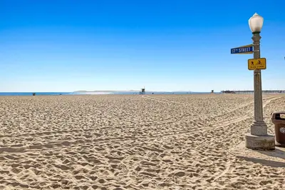a street sign on a sandy beach with a light pole at 1628 West Oceanfront Oasis 7 in Newport Beach