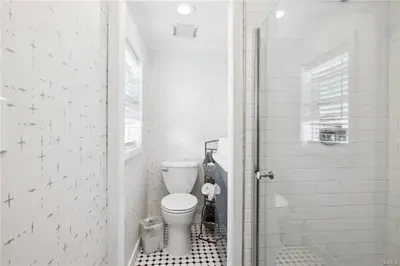 a white bathroom with a toilet and a shower at 1628 West Oceanfront Oasis 9 in Newport Beach