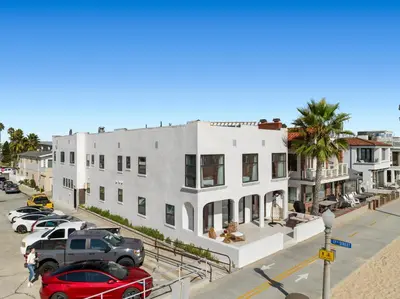 a red car parked in front of a white building at 1628 West Oceanfront Oasis 5 in Newport Beach