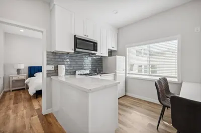 a kitchen with white cabinets and a counter top at 1628 West Oceanfront Oasis 5 in Newport Beach