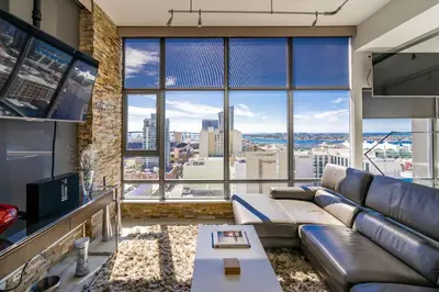 a living room with a couch and a large window at Cityscape Elegance with Water Views in San Diego