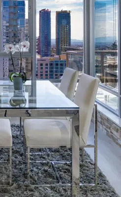 a dining room with a glass table and white chairs at Cityscape Elegance with Water Views in San Diego