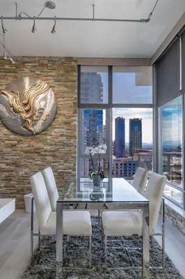 a dining room with a glass table and white chairs at Cityscape Elegance with Water Views in San Diego