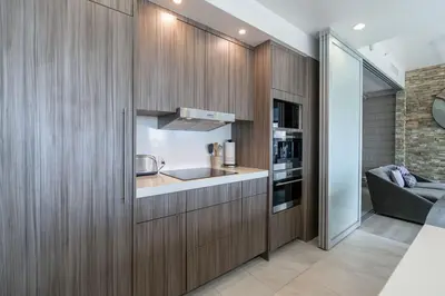 a kitchen with wooden cabinets and a sink and a couch at Cityscape Elegance with Water Views in San Diego