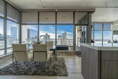 a dining room with a table and chairs and a view of the city at Cityscape Elegance with Water Views in San Diego
