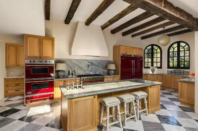 a large kitchen with wooden cabinets and red appliances at Exclusive Spanish Mediterranean Mansion in Rancho Santa Fe