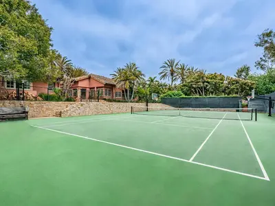 a tennis court in front of a house at Exclusive Spanish Mediterranean Mansion in Rancho Santa Fe