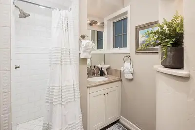 a white bathroom with a shower and a sink at Dolphin's Paradise in San Diego