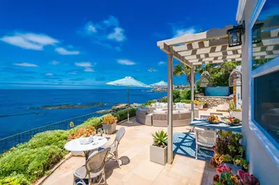 a patio with a table and chairs and the ocean at Dolphin's Paradise in San Diego