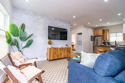 a living room with a blue couch and a kitchen at Newly Remodeled Uptown Chic in San Diego