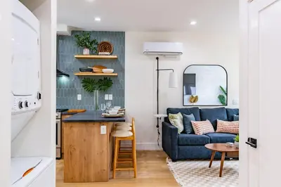 a kitchen and a living room with a blue couch at Newly Remodeled Uptown Chic in San Diego