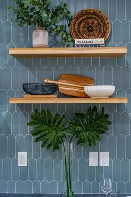 a blue tiled wall with wooden shelves and a plant at Newly Remodeled Uptown Chic in San Diego