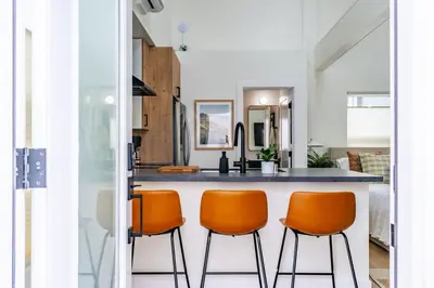 a kitchen with orange chairs at a counter at Swanky Studio in Vibrant Hillcrest in San Diego
