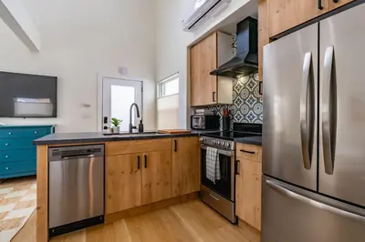 a kitchen with wooden cabinets and stainless steel appliances at Swanky Studio in Vibrant Hillcrest in San Diego