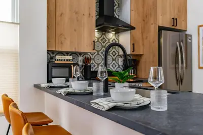 a kitchen with a black counter top with glasses and dishes at Swanky Studio in Vibrant Hillcrest in San Diego