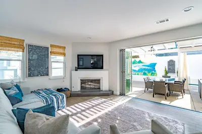 a living room with a couch and a fireplace at Upscale Beach Cottage a Block to the Beach Sauna in Encinitas