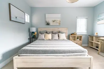 a bedroom with a large bed with blue walls at Upscale Beach Cottage a Block to the Beach Sauna in Encinitas