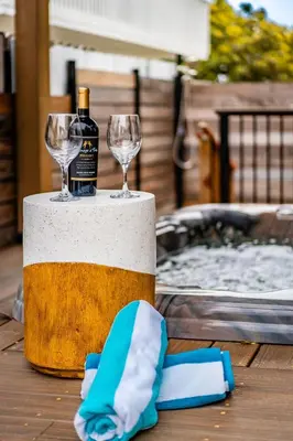 a bottle of wine and two glasses on a table at PB Compound Getaway Steps to Surf and Sand in San Diego