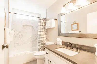 a bathroom with a sink and a toilet and a mirror at PB Compound Getaway Steps to Surf and Sand in San Diego