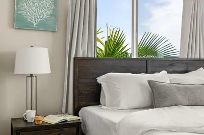 a bedroom with a bed with a wooden headboard and a window at Mission Beach Marvel in San Diego