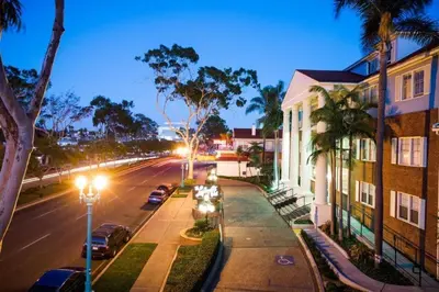 a city street at night with cars parked on the street at The Lafayette Hotel, Swim Club & Bungalows in San Diego