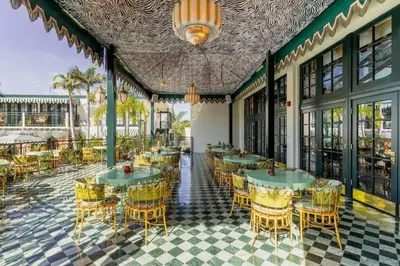 a restaurant with tables and chairs on a patio at The Lafayette Hotel, Swim Club & Bungalows in San Diego