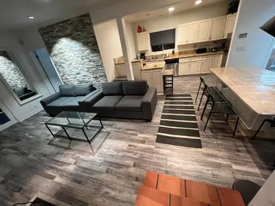 a living room with a couch and a table and a kitchen at Ocean View 5 BR with 3 decks and spa in San Diego