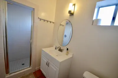a white bathroom with a sink and a mirror at Ocean View 5 BR with 3 decks and spa in San Diego